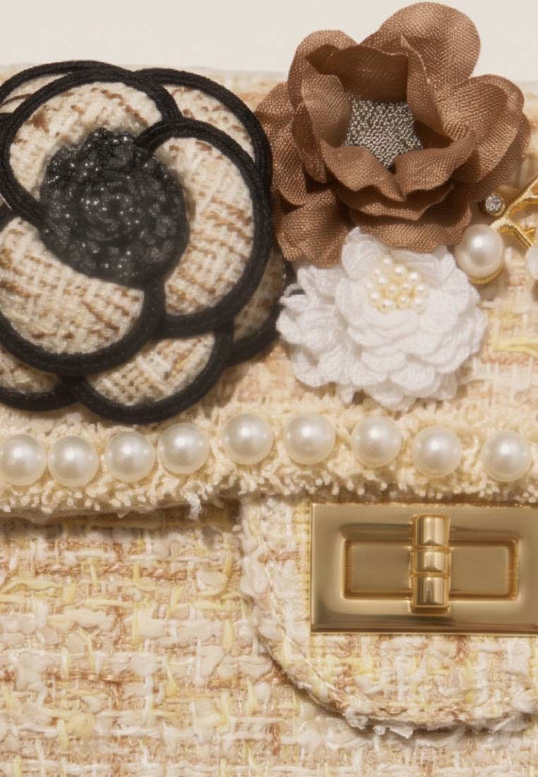 Schmuckzauber Tweed Trachtentasche Glamour beige im Detail mit Perlenband und Blumenapplikationen.